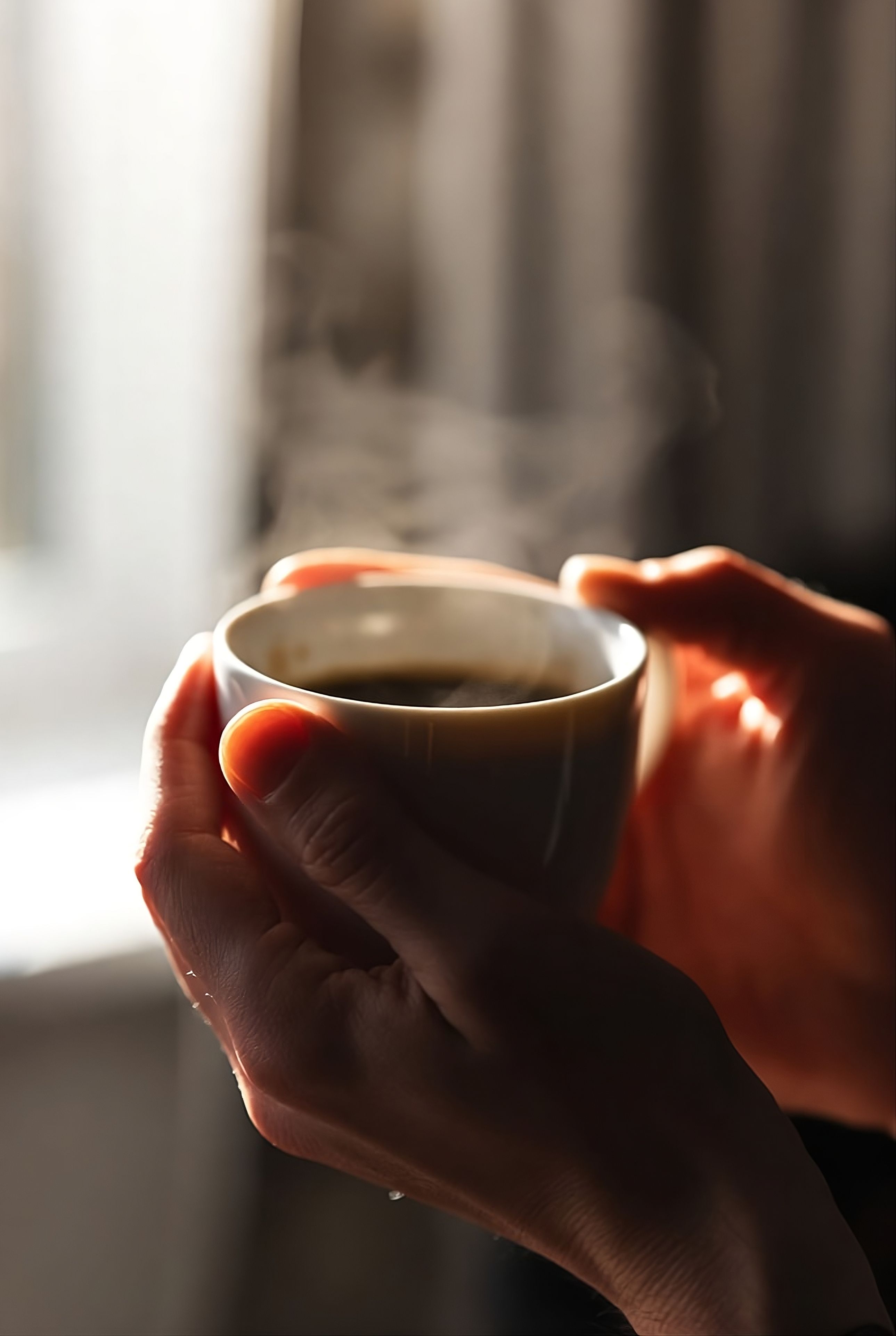 Holding hot coffee cup next to window